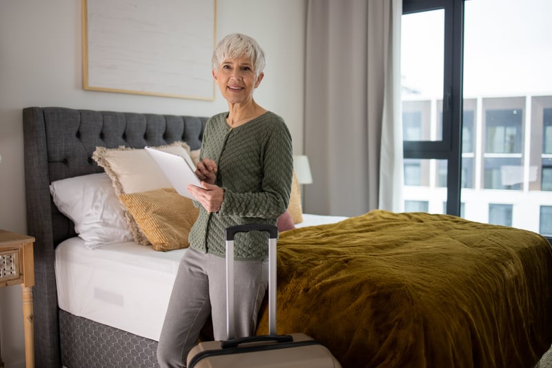 Senior with suitcase in apartment interior